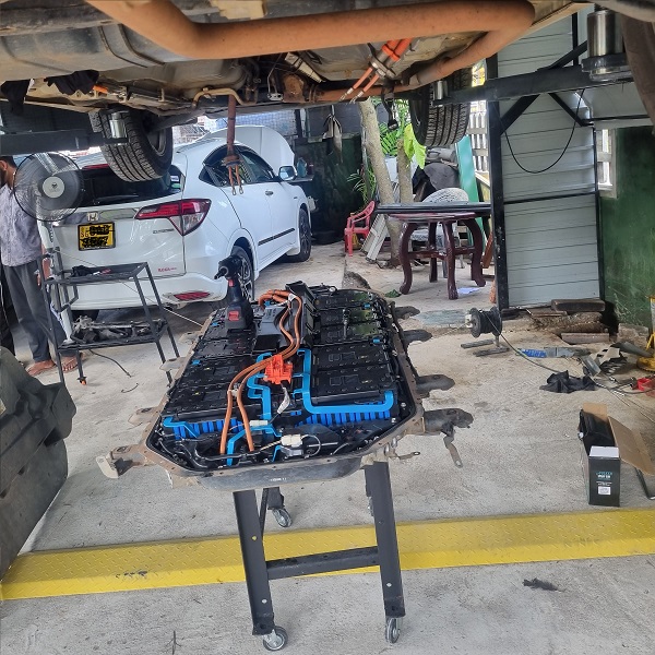 Green Hybrid Care technician servicing a vehicle